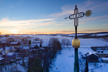 Turmkreuz im Sonnenaufgang im Winter