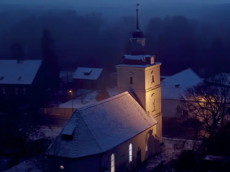 Das Bild zeigt die Dorfkirche im Kirchenkreis Zossen-Fläming in winterlicher Abendstimmung.