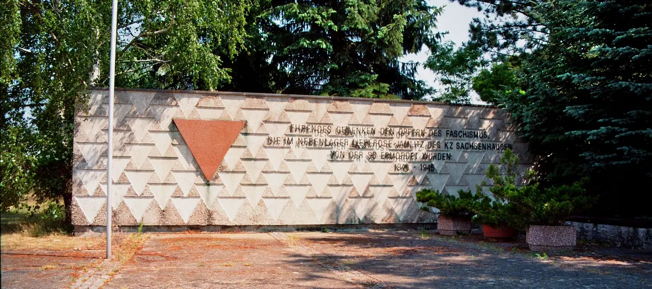 Das Mahnmal gegen Faschismus und Krieg neben dem Friedhof in Lieberose. Die Aufschrift auf der Mauer lautet: Ehrendes Gedenken den Opfern des Faschismus, die im Nebenlager Lieberose-Jamlitz des KZ Sachsenhausen von der SS ermordet wurden. 1943-45. Foto: Wikimedia / JH Janßen